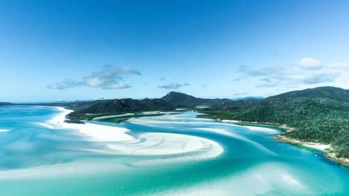 A breathtaking aerial view of a coastal area with clear blue water and white sandbars.