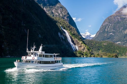 A scenic view of Milford Sound, showcasing its dramatic cliffs, waterfalls, and lush greenery