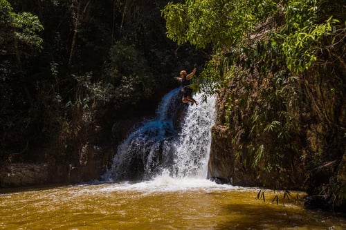 Adventurers jumping down a waterfall in the waters of Dalat