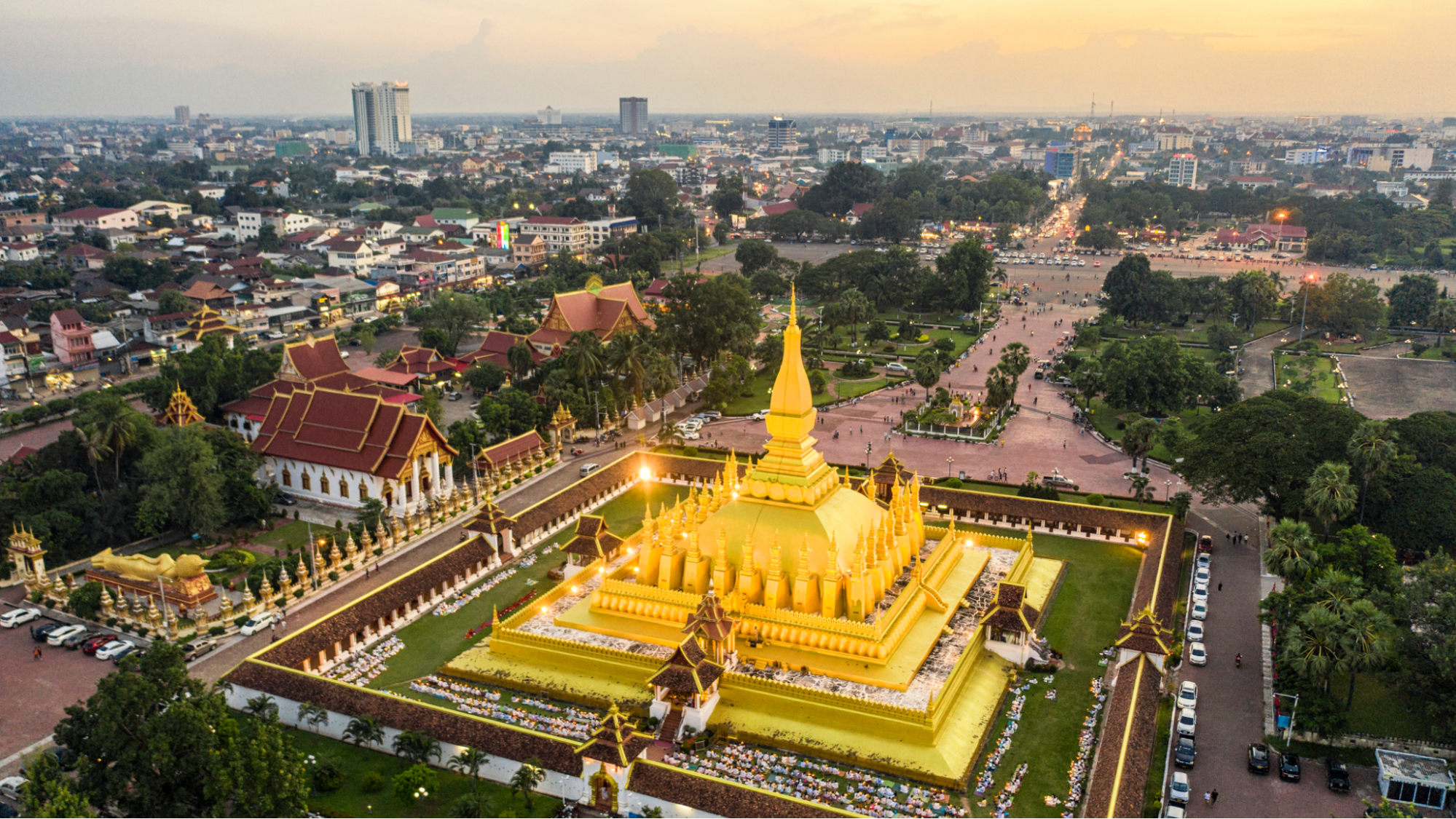 Aerial view of Pha That Luang, a golden stupa illuminated at dusk in Vientiane, Laos