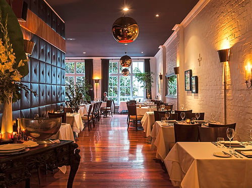 An elegant fine-dining restaurant with soft lighting and luxurious decor, serving a tasting menu with wine pairings.