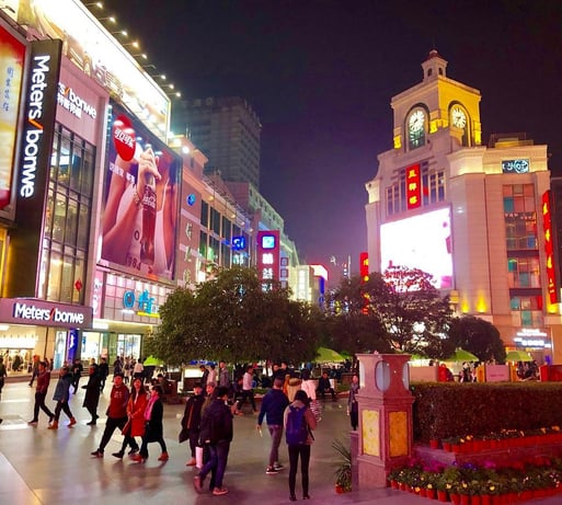 Bustling Chunxi Road filled with shoppers and neon lights, a premier Chengdu tourist attraction.