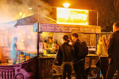 Crowds enjoying vibrant street food stalls at Brisbane_s Night Noodle Markets under evening lights