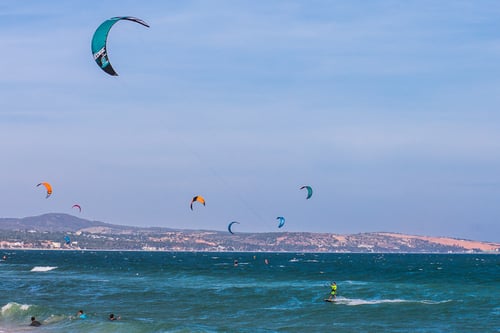 Kitesurfers soaring over the waves in Mui Ne