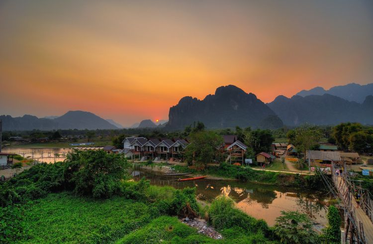 Lush green landscape of Vang Vieng, Laos, with towering karst mountains and the Nam Song River