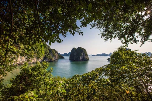 Majestic view of Ha Long Bays limestone karsts and emerald waters during sunset.