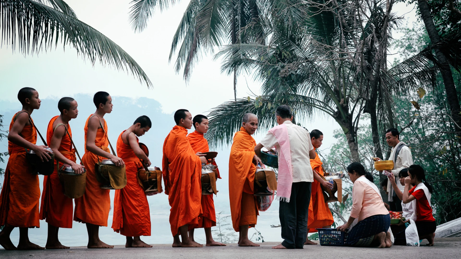 Monks and locals participating in Alms Giving Ceremony in Laos