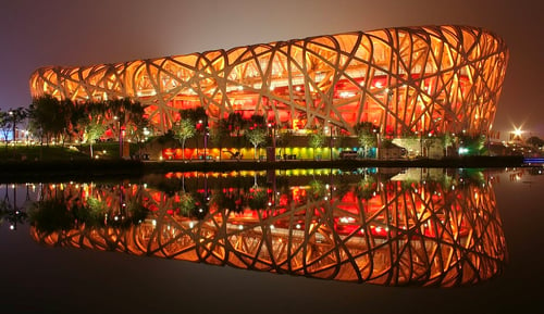 The Beijing National Stadium, illuminated at night, a tourist site.