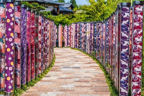 The Kimono Forest in Arashiyama is a stunning display of cylindrical pillars wrapped in vibrant kimono fabrics