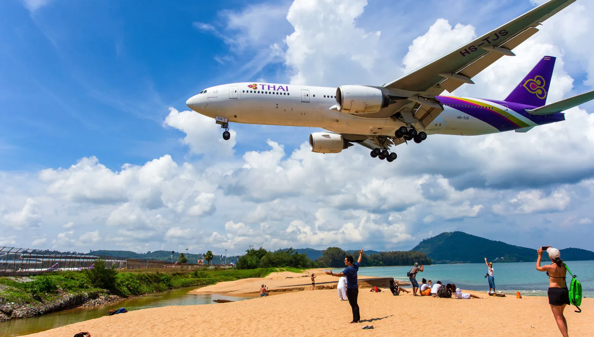 Tourist looking at close-proximity plane at Mai Khao Beach attraction in Phuket