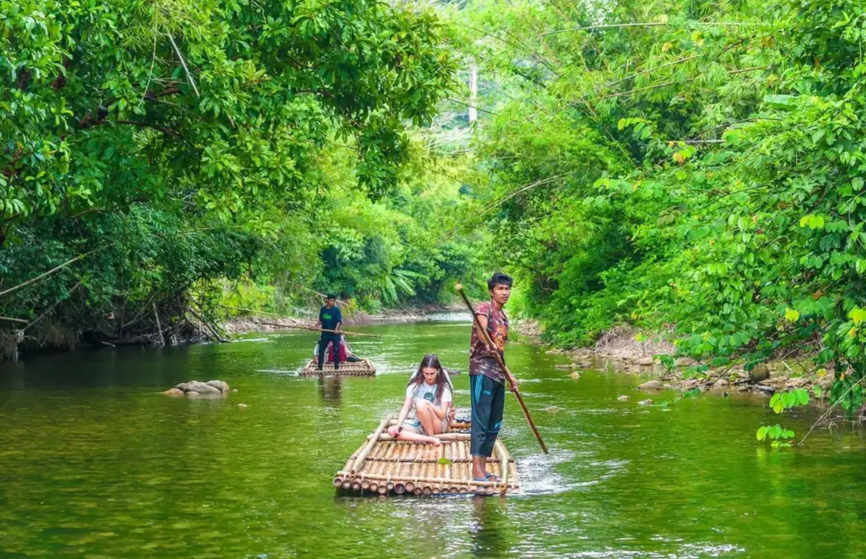 Tourist on a unique experience of sitting on bamboo raft in Phuket