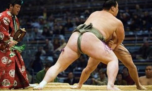 Two sumo wrestlers fighting in the Sumo tournament