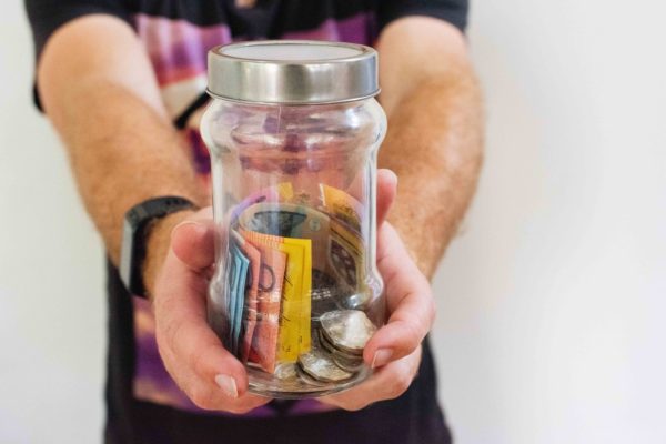 Discover Your Money Personality: The Cheapskate - man holding a money jar