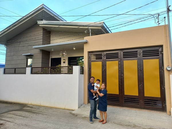 steps to building a house - Pierre and family outside their newly built home steps to building a house - Pierre and family outside their newly built home