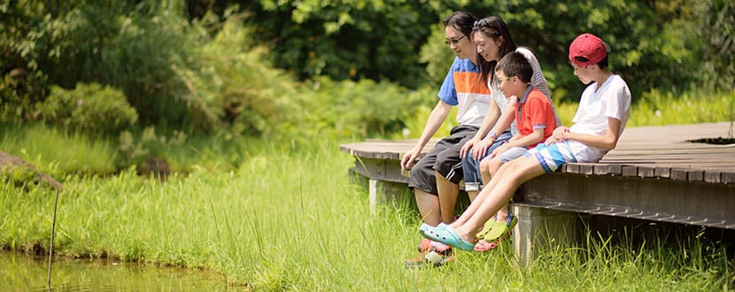 Family sitting at the edge of a bridge -SingSaver