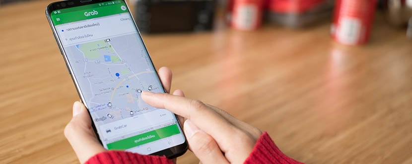 person using Grab app on mobile phone -SingSaver