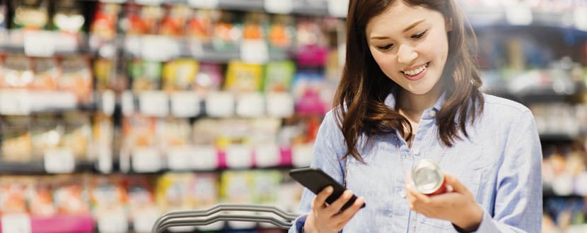 lady using mobile phone while grocery shopping -SingSaver