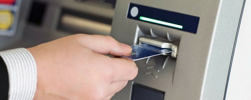 man inserting atm card in machine - SingSaver