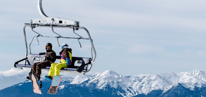 Two travellers with travel insurance on a ski lift