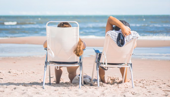 Two travellers with travel insurance relaxing on the beach