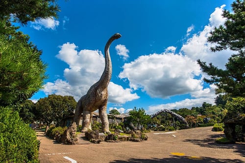 life-size dinosaur statue in a park, a fun spot to spend your days in jeju