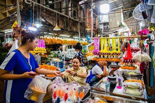market activity with vendors and customers in pak khlong talat, bangkok