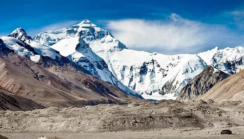 standing at the foot of the peak of mount everest