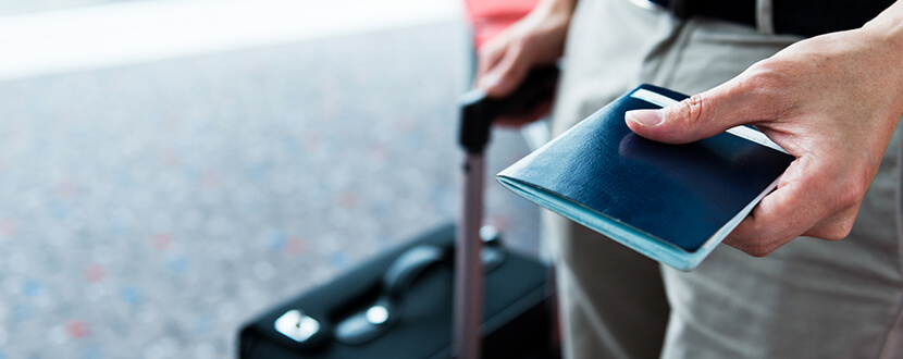 man carrying luggage and passport in airport -SingSaver